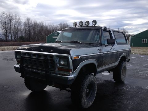 1979 Ford Bronco - This lifted Ford Bronco is parked outdoors on a cloudy day, showing its front three-quarter view.