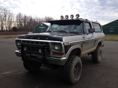 1979 Ford Bronco - This lifted Ford Bronco is parked outdoors with two buildings in the background.