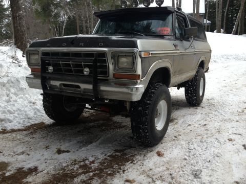 1979 Ford Bronco - This modified Ford Bronco is parked in a snowy environment, off-road tires and a roof-mounted light bar.