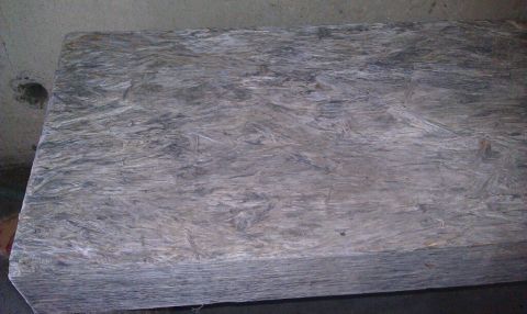 1989 Ford Bronco - A stack of plywood sheets is visible in a dimly lit area.