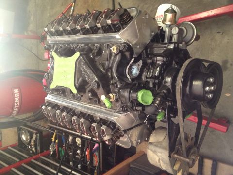 1965 Ford Mustang - A V8 engine is shown with various components and tools nearby.
