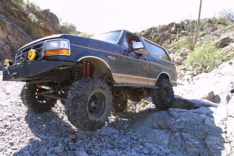 1994 Ford Bronco - Modified Ford Bronco navigates a rocky off-road trail.