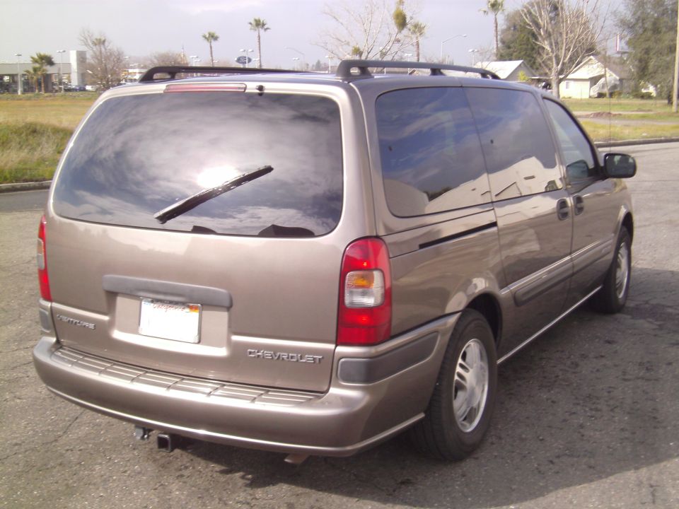 Tan 2005 Chevrolet Venture minivan, rear 3/4 view, with roof rack and trailer hitch
