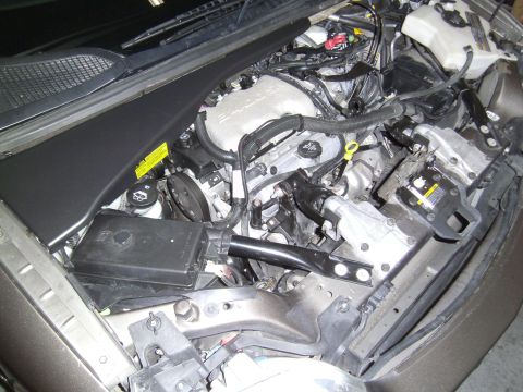 2005 Chevrolet Venture - The engine bay of a vehicle is shown with various mechanical and electrical parts.