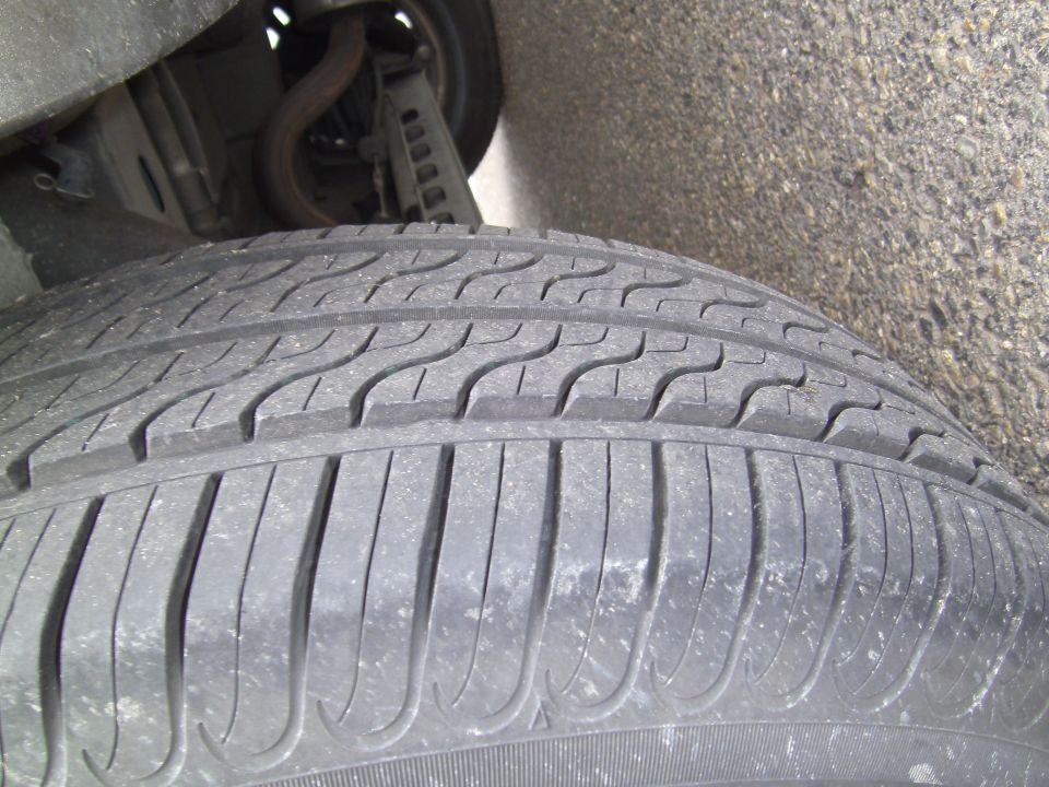 Close-up of a tire tread with suspension components visible above