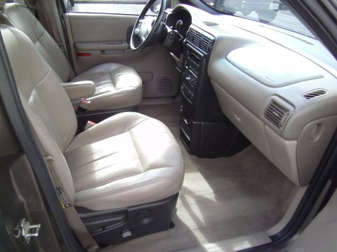 2005 Chevrolet Venture - The interior of a minivan shows the front passenger and driver seats, dashboard, and center console.