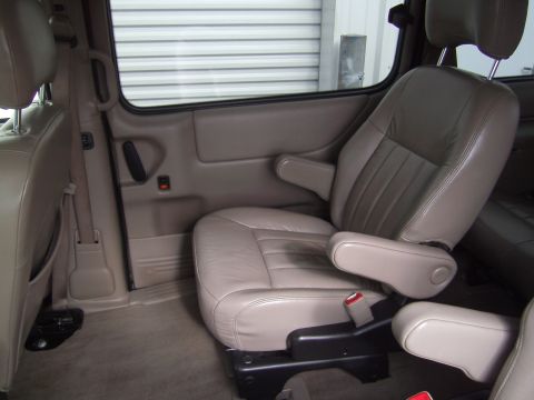 2005 Chevrolet Venture - The interior of a van shows tan leather captain's chairs with armrests and seatbelts visible.