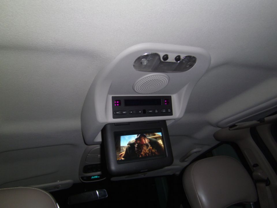 overhead screen showing a movie, with audio controls and lights above it