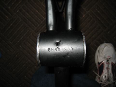 1994 Ford Bronco - A close-up view of a black metal tube with a stamped serial number, possibly a vehicle part.