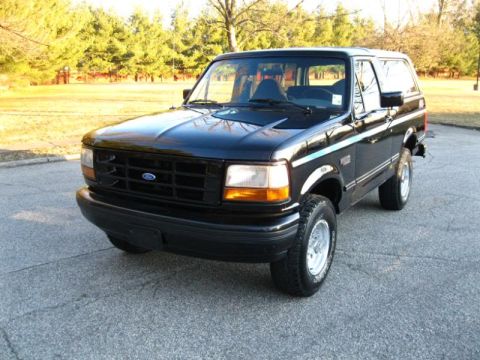1994 Ford Bronco - This black 1994 Ford Bronco is shown from a front three-quarter angle on an asphalt surface.