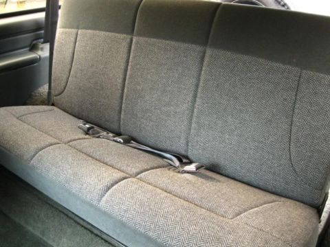1994 Ford Bronco - Interior view of a vehicle's rear seat with a patterned fabric upholstery and seatbelt.