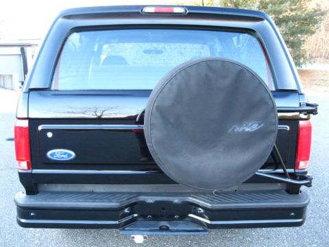 1994 Ford Bronco - The rear of a black Ford Bronco shows its spare tire mounted externally.