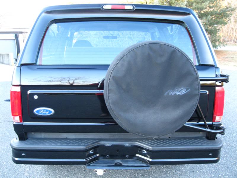 Rear view of a black 1994 Ford Bronco with a spare tire cover that says Nite