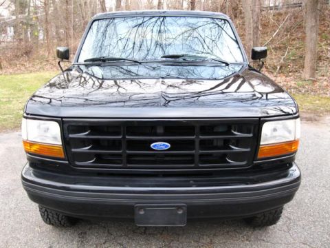 1994 Ford Bronco - Front view of a black 1994 Ford Bronco, its distinctive grille and Ford emblem.