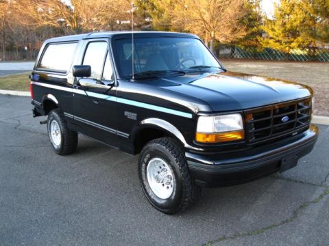 1994 Ford Bronco - Black 1994 Ford Bronco Nite Edition parked on asphalt with trees in the background.