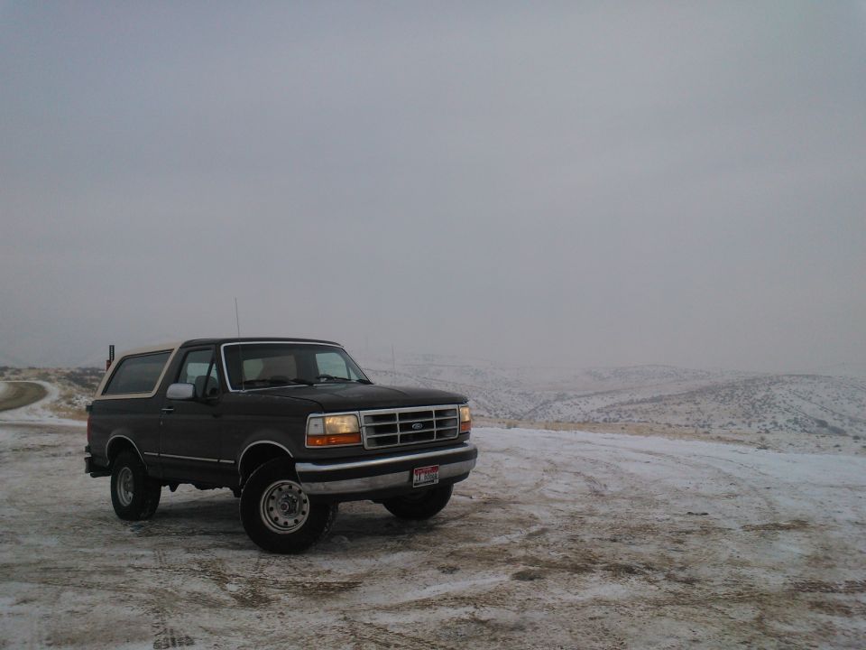 Dark 1992 Ford Bronco with white top in snowy landscape