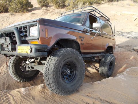 1986 Ford Bronco II - This modified 1986 Ford Bronco II navigates a sandy, off-road path with its large tires and lifted suspension.