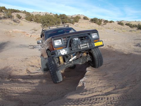 1986 Ford Bronco II - This modified Ford Bronco II is attempting to traverse a challenging off-road obstacle.