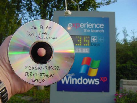 1988 Ford Bronco - A CD labeled 'Win XP Pro Corp. Final Devil's Own' is held up in front of a Windows XP promotional sign.