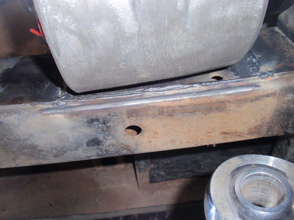 Close-up of rusty frame with a metal suspension component