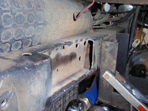 1971 Ford Bronco - A close-up view of a vehicle's frame, showing signs of wear and tear, with a tire and electrical components in the background.