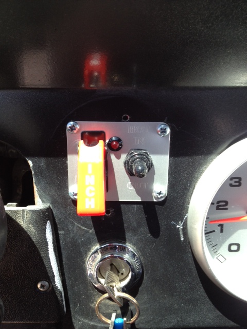 1971 Ford Bronco - Close-up of a vehicle's dashboard showing a winch control switch and ignition with keys.