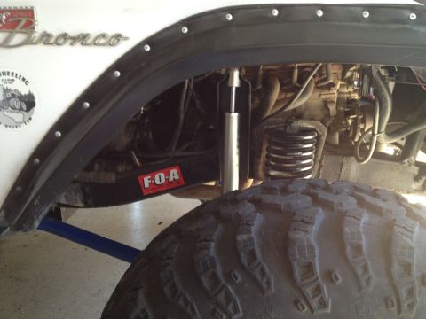 1971 Ford Bronco - Close-up view of the suspension and tire on a white 1971 Ford Bronco.