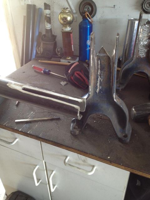 1971 Ford Bronco - Custom suspension components and tools are laid out on a workbench, suggesting ongoing automotive work.