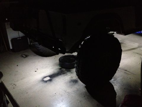 1971 Ford Bronco - Rock lights illuminate the undercarriage of a vehicle, highlighting suspension components and tires.