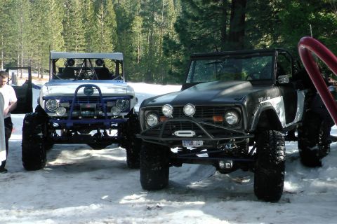 1971 Ford Bronco - Two heavily modified 1971 Ford Broncos are parked in the snow, ready for off-road adventure.