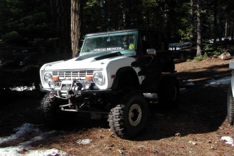 1971 Ford Bronco - A modified white Ford Bronco sits in a snowy, wooded area, displaying a "NorCal Broncos" sticker on its windshield.