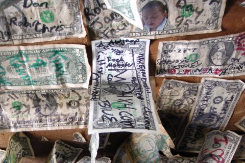 1971 Ford Bronco - Several US dollar bills are covered in handwritten messages and names, with one bill a photograph of a sleeping baby.