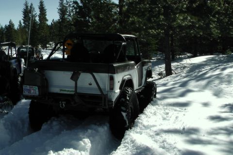 1971 Ford Bronco - 1971 Ford Bronco navigating a snowy trail with another vehicle following.