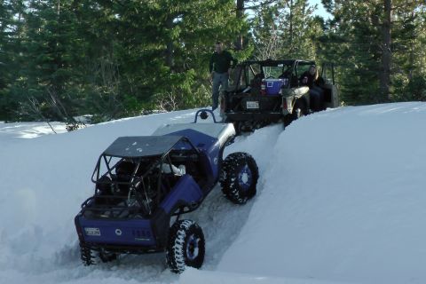 1971 Ford Bronco - Two off-road vehicles navigate a snow-covered trail in a wooded area.