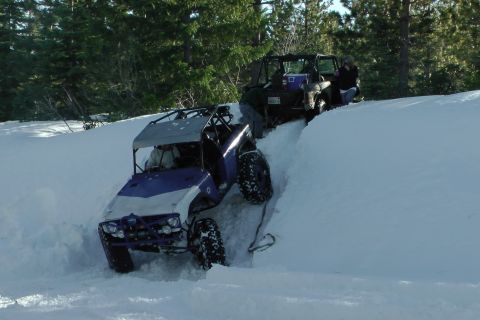1971 Ford Bronco - Two off-road vehicles navigate a snowy trail, with one vehicle appearing to be stuck or struggling.
