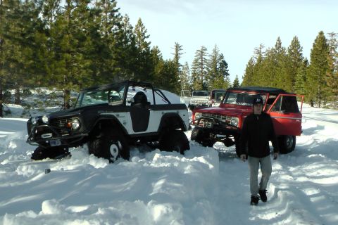 1971 Ford Bronco - Two 1971 Ford Broncos navigate a snowy terrain, with one appearing stuck in deep snow.