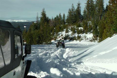 1971 Ford Bronco - Off-road vehicles driving through snow on a mountain road.