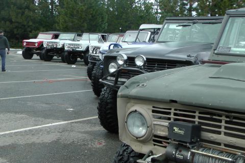 1971 Ford Bronco - Several Ford Broncos are parked in a lot, with a tan one in the foreground.