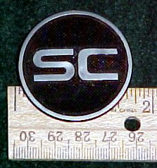 2003 Ford Expedition - Close-up of an SC emblem, shown with a ruler for scale.