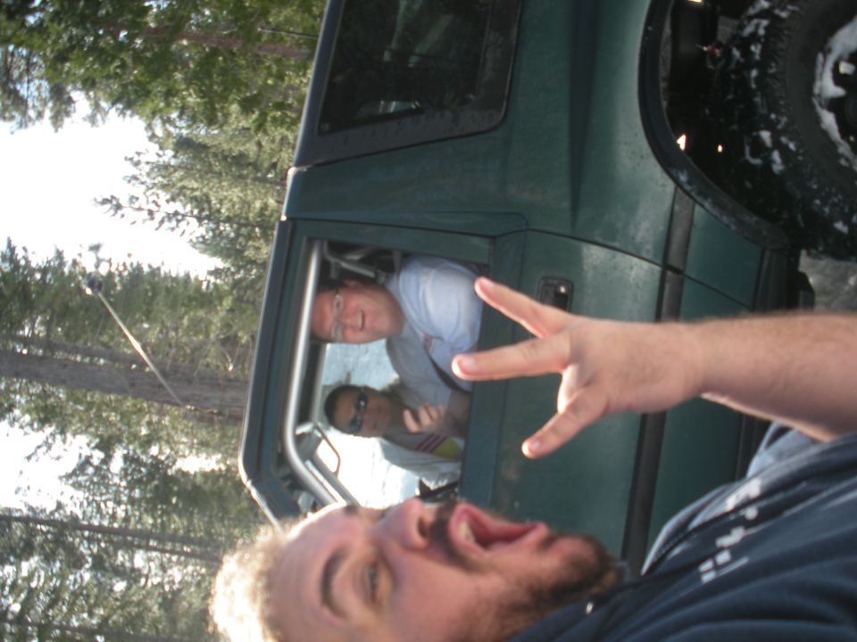 Green SUV interior with people, one making peace sign