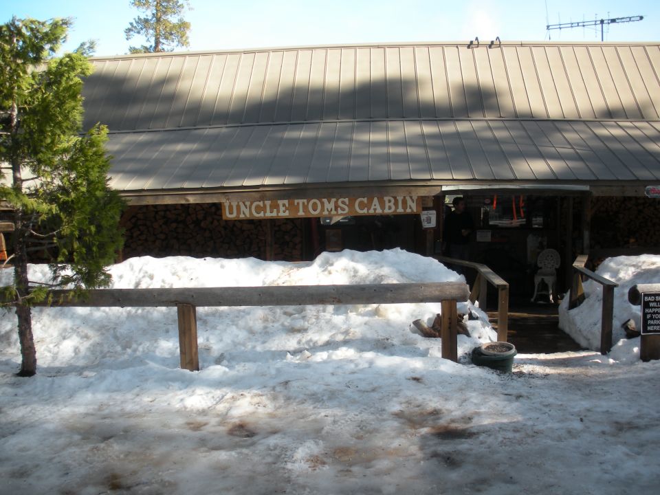 Uncle Tom's Cabin building entrance covered in snow, with a wooden sign above