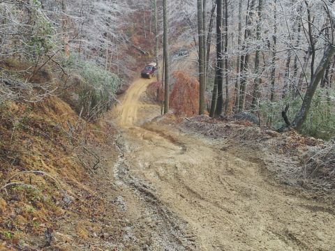 1986 Ford Bronco - Vehicle navigates a challenging muddy incline on a winter day.