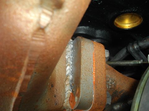 1989 Ford Probe - Welded exhaust manifold flange shows signs of rust and wear.
