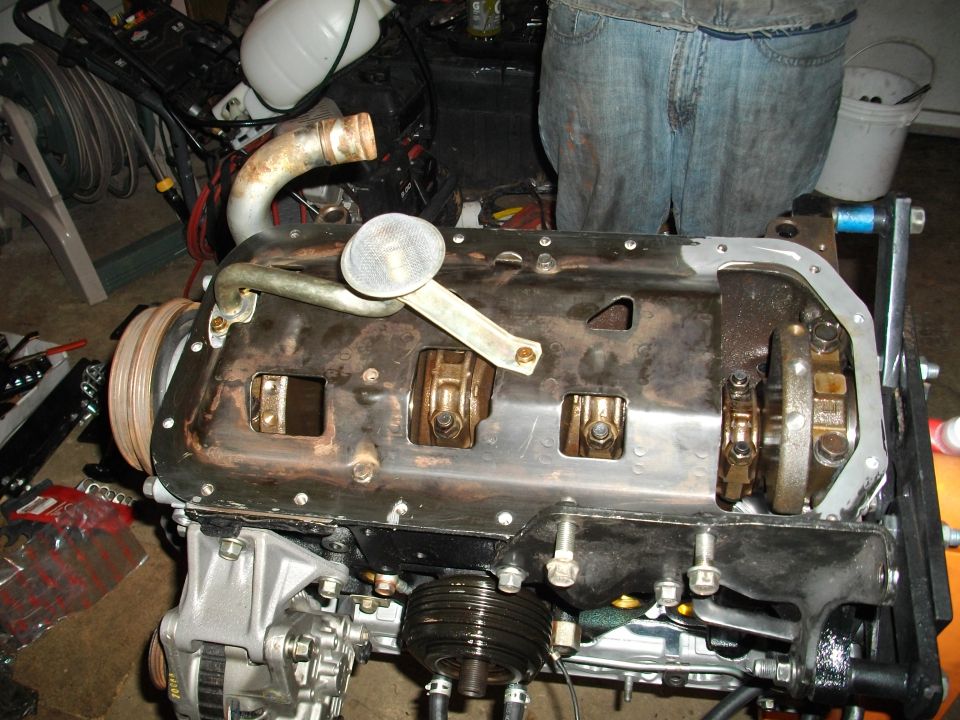Engine block with oil pan removed, showing crankshaft and connecting rods