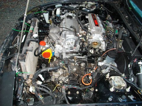 1989 Ford Probe - Engine bay of a V6 with turbocharger and radiator, wires and hoses are visible.