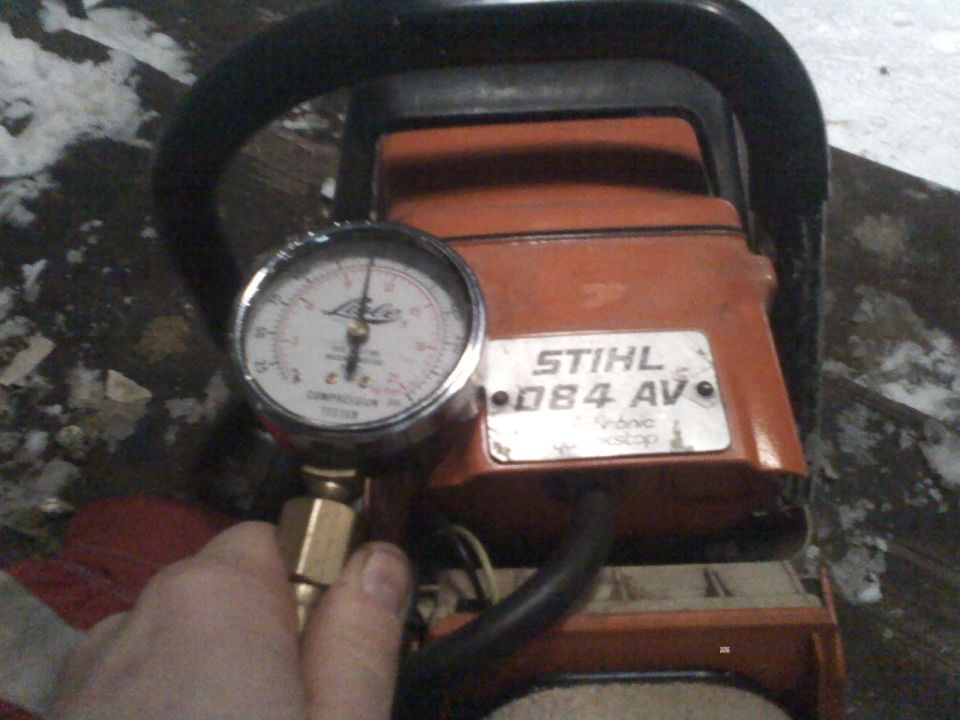 Chainsaw with compression tester attached to gauge