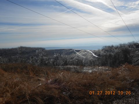 1986 Ford Bronco - A winter scene unfolds with power lines overhead and a distant view of a landfill under a cloudy sky.