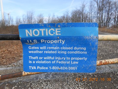 1986 Ford Bronco - A weathered blue sign on a gate warns of closure due to icing and theft, with TVA Police contact info.