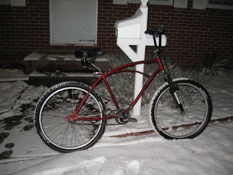 1994 Ford Bronco - A red bicycle with wide tires sits in the snow beside a white mailbox and brick house.