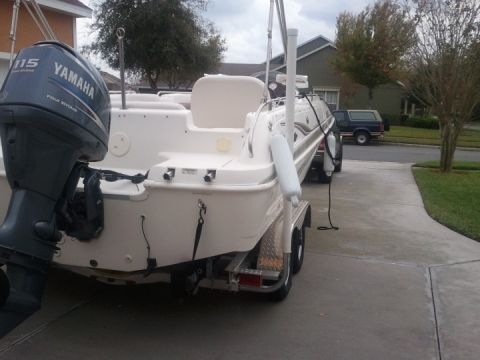 1994 Ford Bronco - A boat with a Yamaha outboard motor is parked on a trailer in a driveway, with a house and trees in the background.